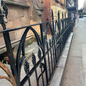 Sanding the Rusted Fence Around the Church